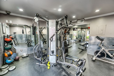 a gym with weights and cardio equipment on the floor and a door